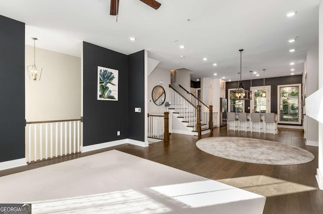 foyer with dark hardwood / wood-style flooring and ceiling fan with notable chandelier