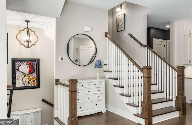 staircase featuring hardwood / wood-style flooring and an inviting chandelier