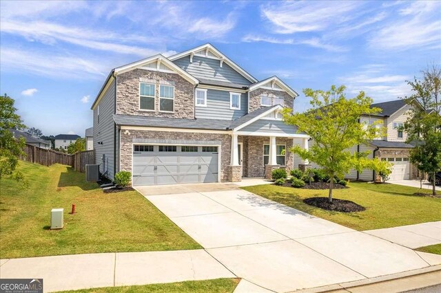 craftsman-style home featuring central air condition unit, a front yard, and a garage