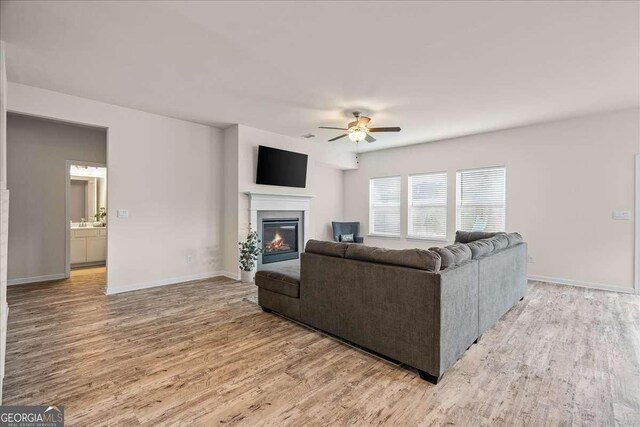 living room featuring ceiling fan and light hardwood / wood-style floors