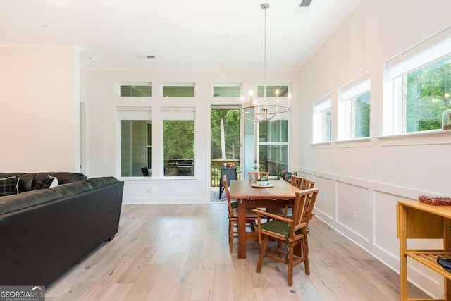 dining area featuring light hardwood / wood-style floors and a notable chandelier