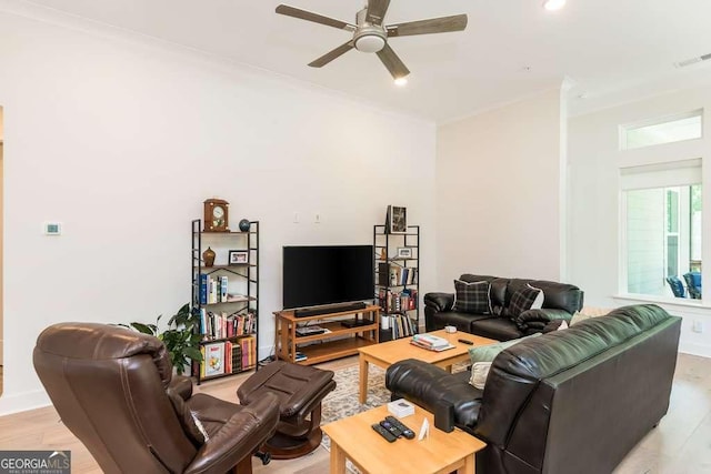 living room featuring crown molding, ceiling fan, and light hardwood / wood-style flooring