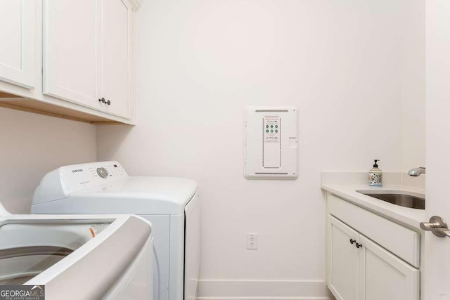 washroom with washer and dryer, cabinets, and sink