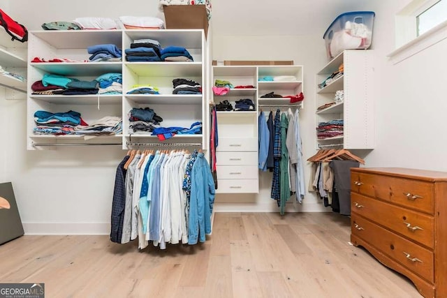 walk in closet with light hardwood / wood-style flooring