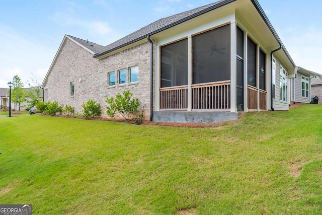 view of side of home with a lawn and a sunroom