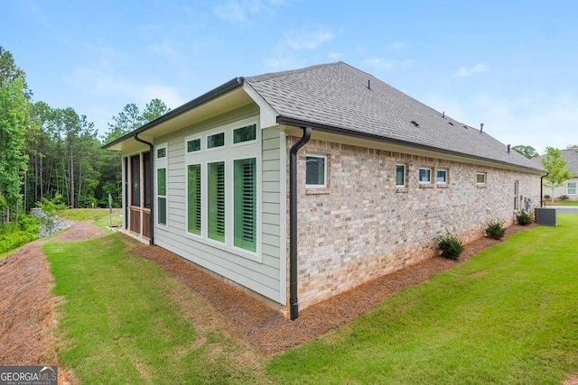 view of side of property with a yard and central AC unit