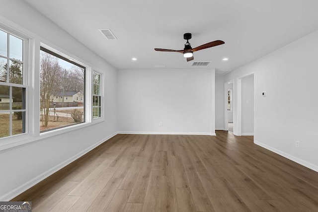 empty room featuring baseboards, visible vents, wood finished floors, and recessed lighting