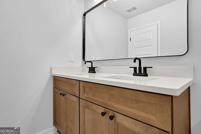 bathroom featuring double vanity, baseboards, visible vents, and a sink