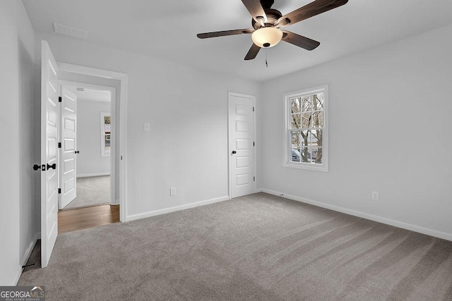 unfurnished bedroom with carpet floors, visible vents, ceiling fan, and baseboards