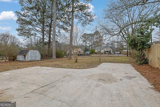 view of yard featuring an outdoor structure, a storage shed, and fence