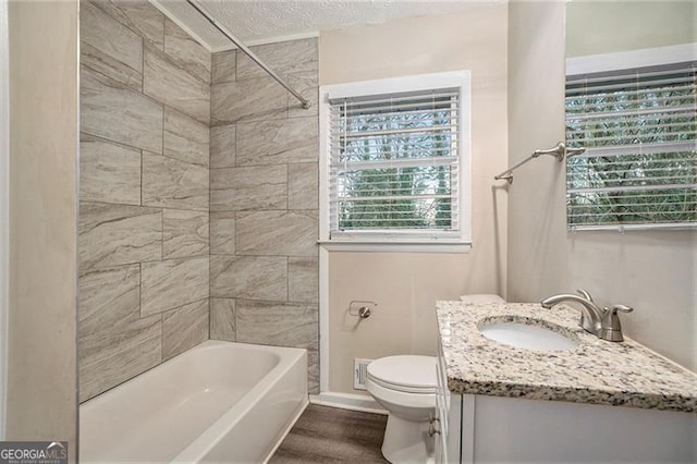 full bathroom with toilet, vanity, and tiled shower / bath