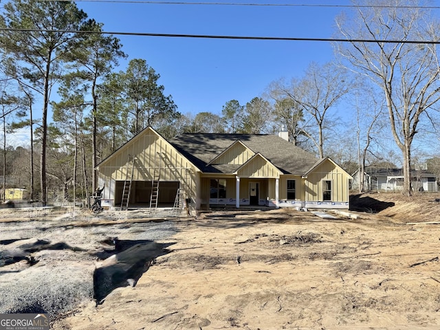 unfinished property featuring a shingled roof and board and batten siding