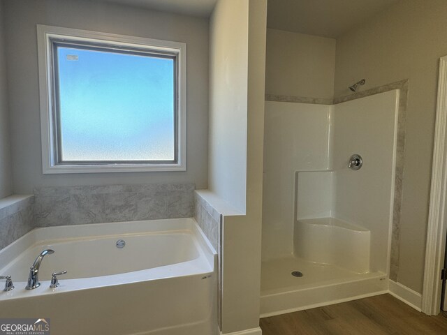 bathroom with independent shower and bath and wood-type flooring