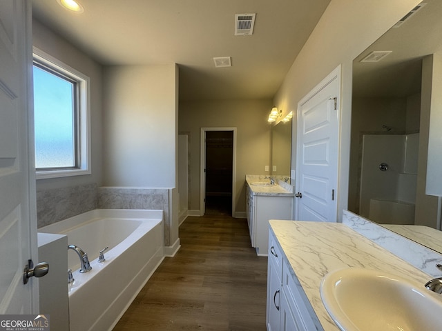 bathroom with shower with separate bathtub, wood-type flooring, and vanity