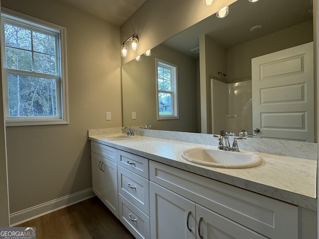 bathroom with hardwood / wood-style floors, a shower, and vanity