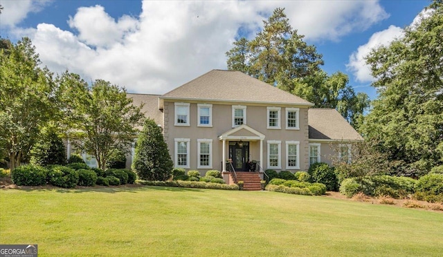 colonial inspired home with a front lawn