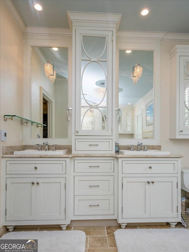 bathroom with ornamental molding, vanity, and toilet