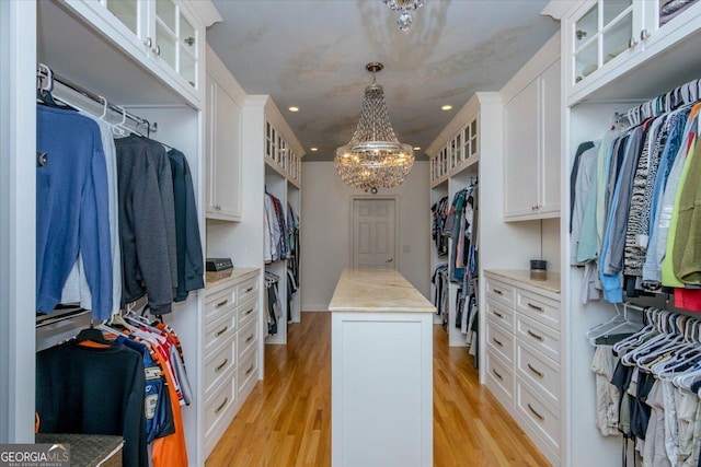 walk in closet with light hardwood / wood-style flooring