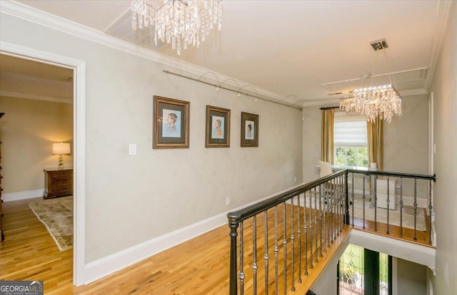 corridor with a chandelier, ornamental molding, and hardwood / wood-style flooring