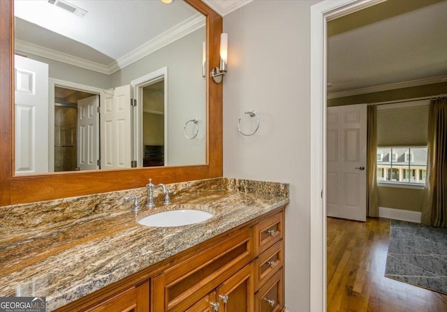 bathroom featuring wood-type flooring, vanity, and crown molding