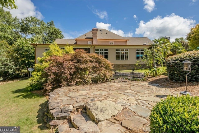 rear view of house featuring a yard and a patio