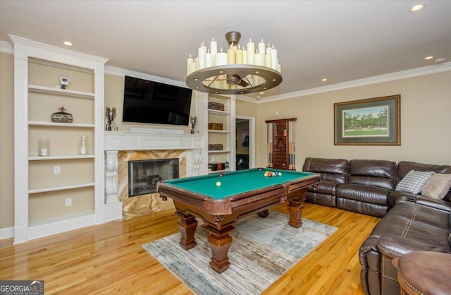 rec room with pool table, crown molding, built in shelves, and hardwood / wood-style flooring