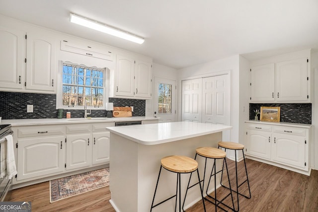 kitchen with sink, plenty of natural light, white cabinetry, and a center island