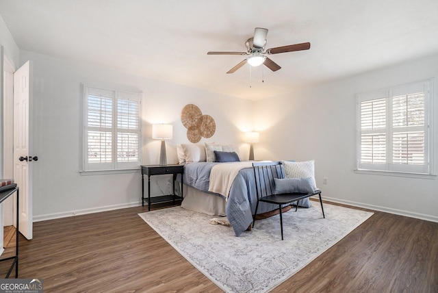 bedroom with multiple windows, dark hardwood / wood-style floors, and ceiling fan