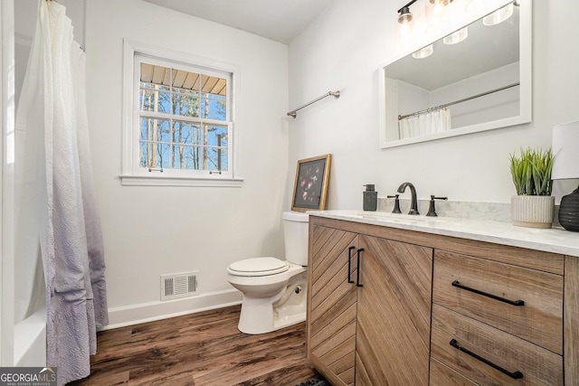 bathroom with hardwood / wood-style flooring, toilet, and vanity