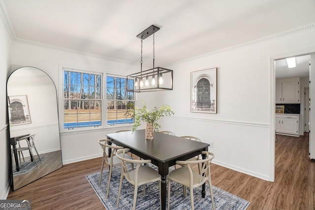 dining space featuring dark wood-type flooring and ornamental molding