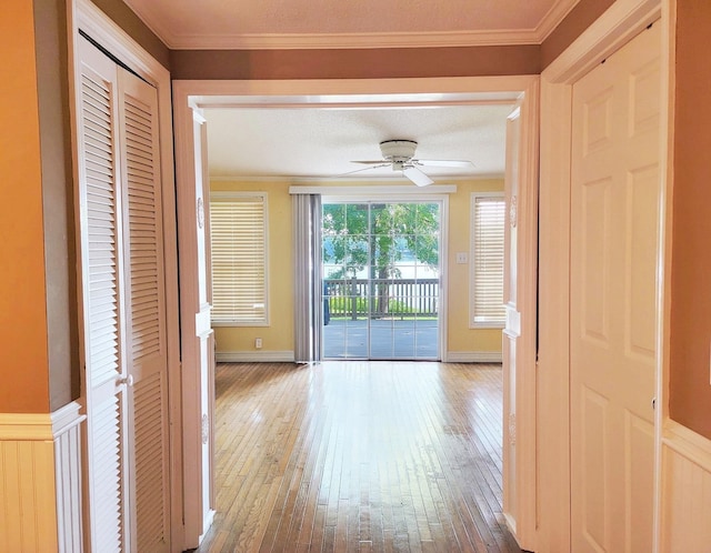 hall with a textured ceiling, ornamental molding, and hardwood / wood-style flooring