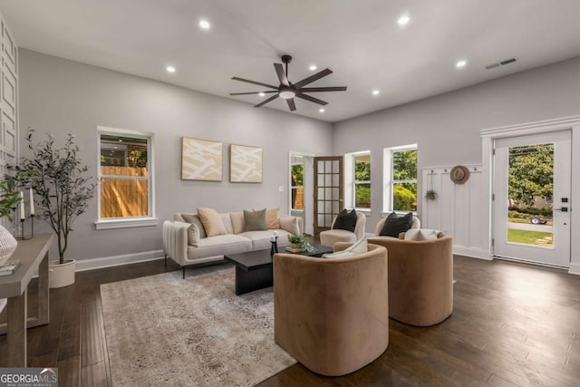 living room with ceiling fan and dark wood-type flooring