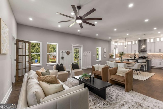 living room featuring ceiling fan, dark hardwood / wood-style flooring, a healthy amount of sunlight, and sink