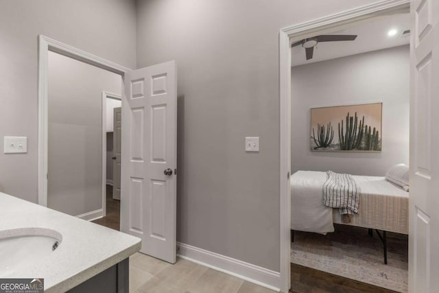 bathroom with ceiling fan, hardwood / wood-style floors, and vanity