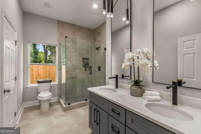 bathroom with a healthy amount of sunlight, an enclosed shower, and toilet