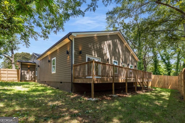 rear view of house featuring a yard and a deck