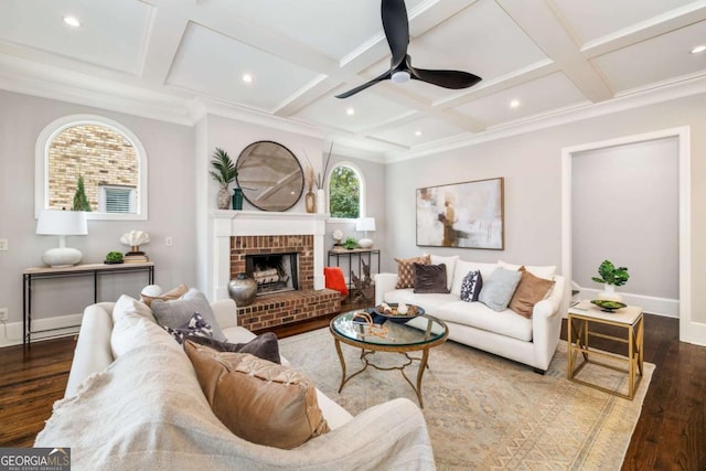 living room featuring ceiling fan, dark wood-type flooring, coffered ceiling, and a brick fireplace