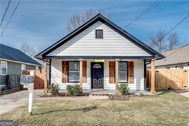 bungalow with a front yard and covered porch