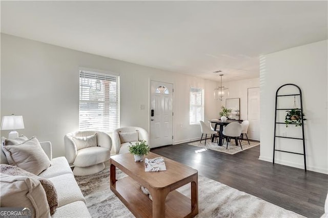 living room featuring dark hardwood / wood-style flooring, a chandelier, and plenty of natural light