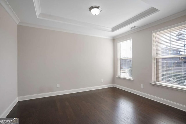 unfurnished room featuring crown molding, dark hardwood / wood-style floors, and a tray ceiling