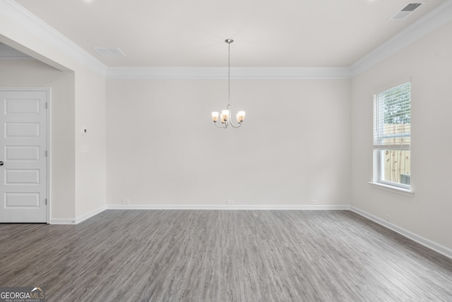 empty room featuring ornamental molding, a notable chandelier, and hardwood / wood-style floors