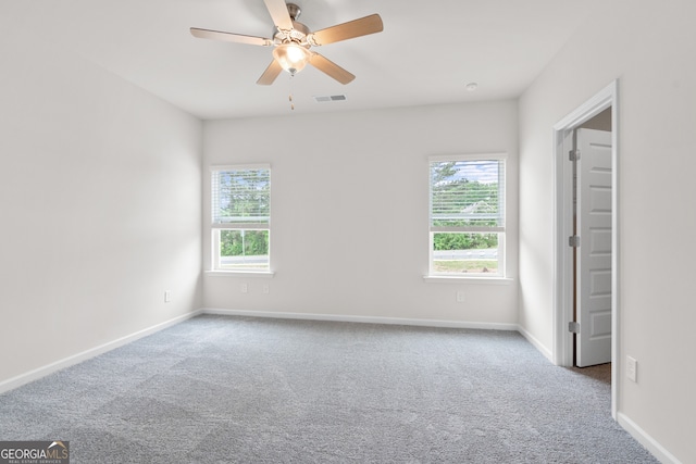 carpeted spare room featuring ceiling fan