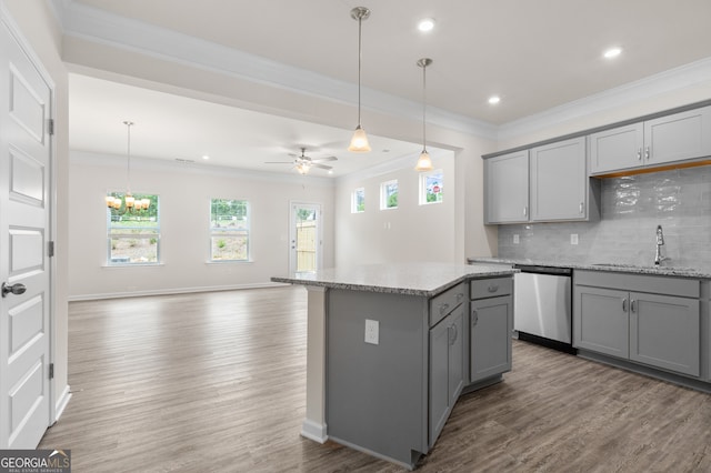 kitchen with light stone counters, stainless steel dishwasher, ceiling fan with notable chandelier, hanging light fixtures, and gray cabinets