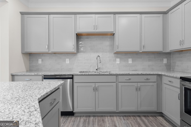 kitchen featuring stainless steel appliances, gray cabinets, light stone countertops, and sink