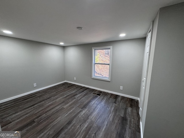 unfurnished room with dark wood-type flooring