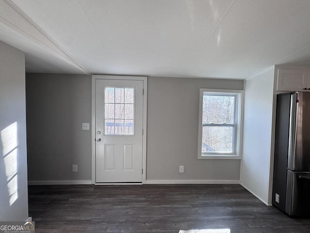 foyer featuring a textured ceiling, dark wood-type flooring, and plenty of natural light