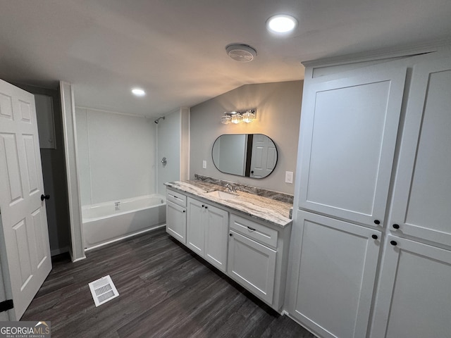 bathroom featuring wood-type flooring, vanity, and a washtub