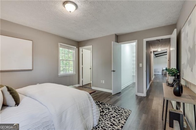 bedroom featuring a textured ceiling and dark wood-type flooring