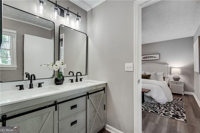 bathroom featuring hardwood / wood-style flooring, a textured ceiling, crown molding, and vanity