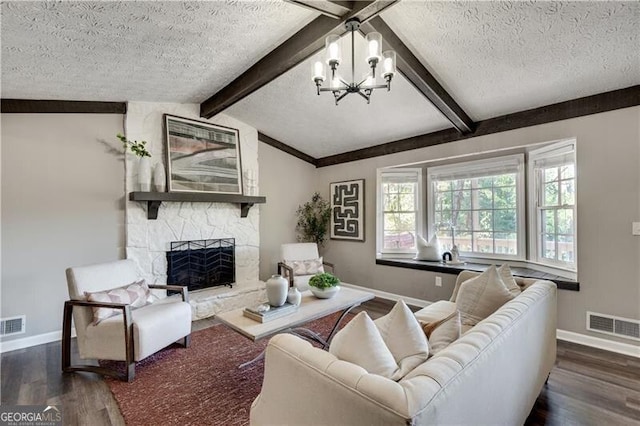 living room featuring vaulted ceiling with beams, a notable chandelier, dark wood-type flooring, a fireplace, and a textured ceiling